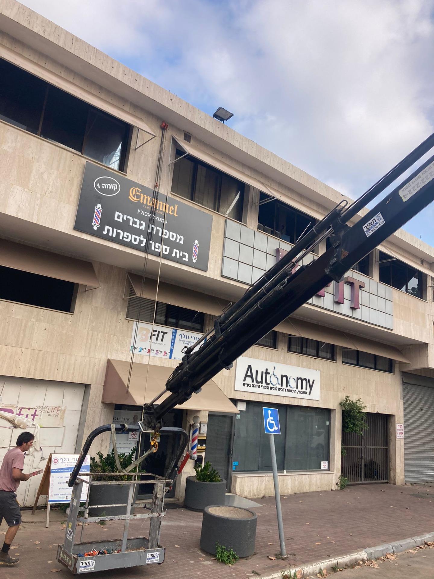 זרוע מנוף מול חזית חנות